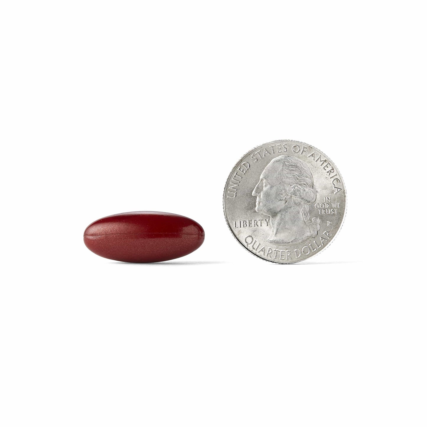 A MegaRed Advanced Total Body pill next to a quarter coin 